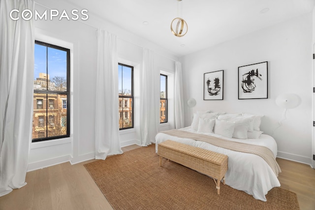 bedroom featuring baseboards and wood finished floors