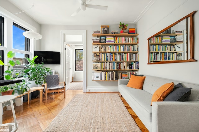 sitting room with ceiling fan and ornamental molding