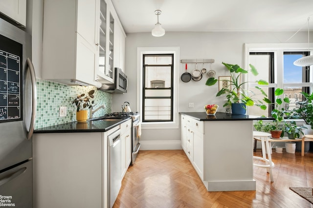 kitchen with dark countertops, stainless steel appliances, and a wealth of natural light