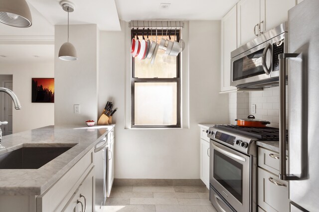 74 W 68th St Unit 6C, New York City, NY 10023 - kitchen with stainless steel appliances, a sink, tasteful backsplash, baseboards, and light stone countertops