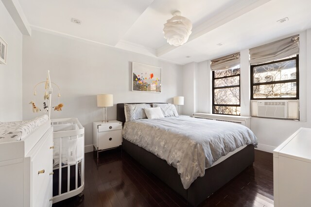 74 W 68th St Unit 6C, New York City, NY 10023 - bedroom with dark wood-style flooring, cooling unit, crown molding, and a tray ceiling
