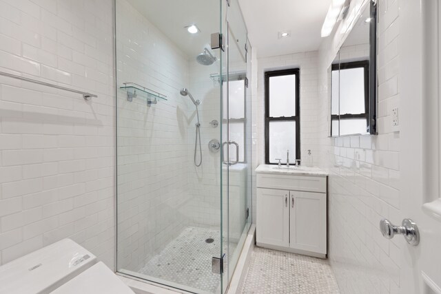 74 W 68th St Unit 6C, New York City, NY 10023 - bathroom with a stall shower, tile patterned flooring, vanity, tile walls, and recessed lighting