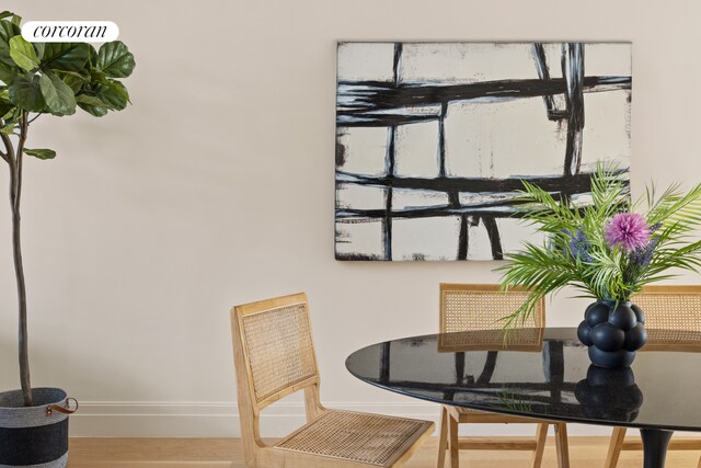 dining space featuring wood finished floors and baseboards
