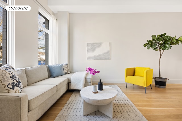 living area with baseboards and wood finished floors