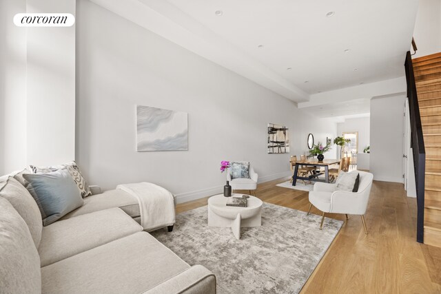 living area featuring light wood-type flooring, baseboards, stairway, and visible vents