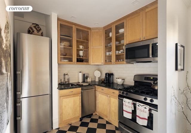 155 E 93rd St Unit 11G, New York City, NY 10128 - kitchen with stainless steel appliances, backsplash, glass insert cabinets, dark stone countertops, and light floors