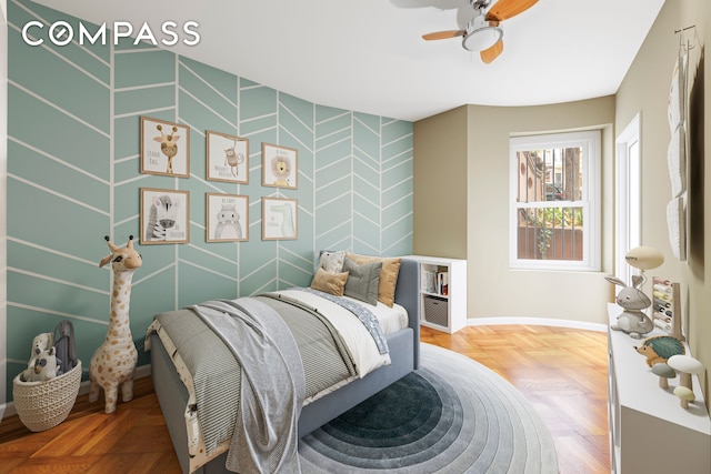 bedroom with an accent wall, baseboards, and ceiling fan