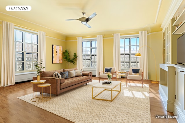 living room with wood finished floors, ceiling fan, and ornamental molding