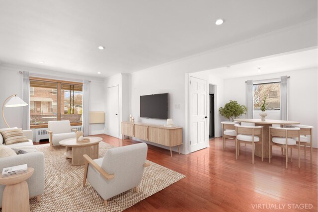 living room with crown molding, recessed lighting, plenty of natural light, and wood finished floors