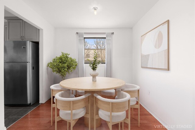 dining space with baseboards and dark wood-style floors