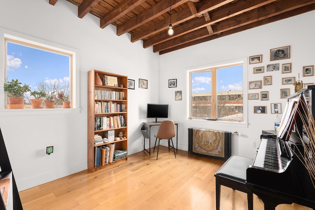 living area featuring baseboards, wooden ceiling, beam ceiling, and wood finished floors