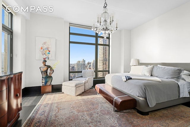 450 E 83rd St Unit Ph1B, New York City, NY 10028 - bedroom featuring a city view, wood finished floors, an inviting chandelier, and expansive windows