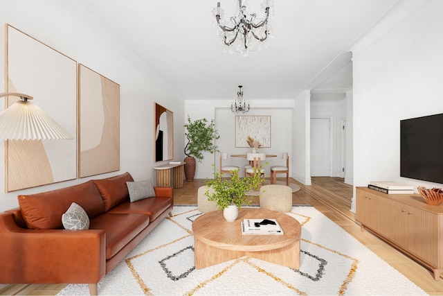 living room with an inviting chandelier, baseboards, and light wood-style floors