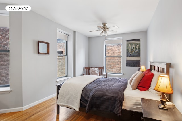 bedroom with wood finished floors, baseboards, and ceiling fan