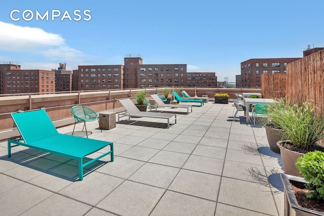 view of patio / terrace featuring a view of city and fence