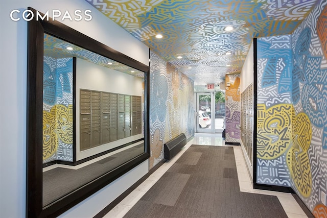 hallway featuring wallpapered walls and mail area