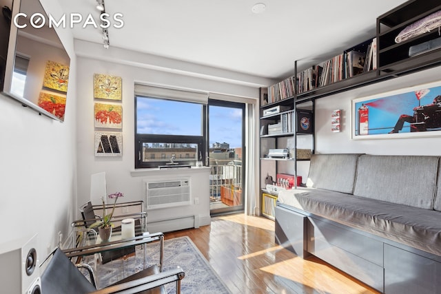 456 W 167th St Unit 7C, New York City, NY 10032 - living area with wood finished floors, an AC wall unit, and a desk