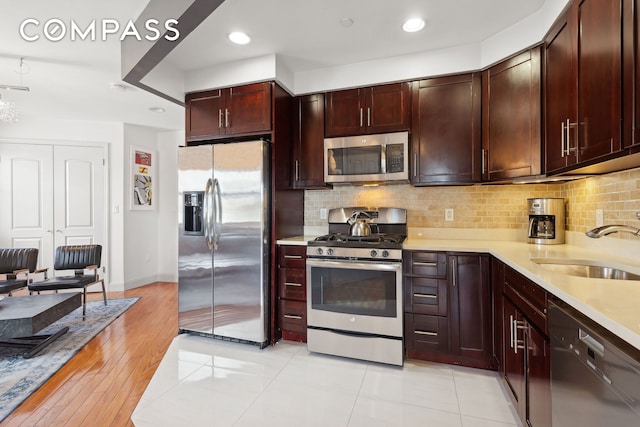456 W 167th St Unit 7C, New York City, NY 10032 - kitchen featuring stainless steel appliances, light countertops, a sink, backsplash, and recessed lighting
