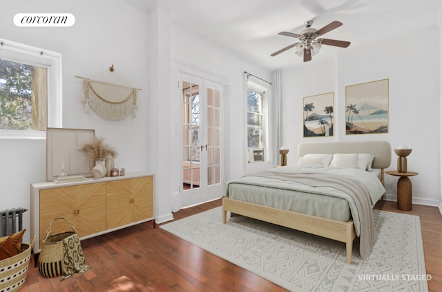 bedroom featuring radiator heating unit, wood finished floors, visible vents, and ceiling fan