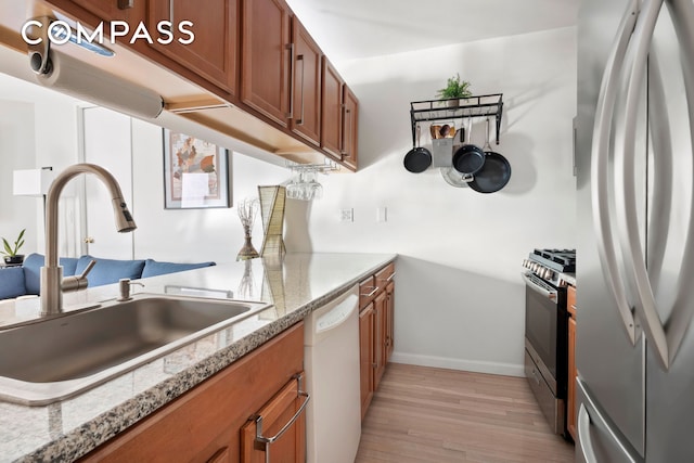 350 W 50th St Unit 3Ll, New York City, NY 10019 - kitchen featuring stainless steel appliances, a sink, brown cabinets, and light wood finished floors