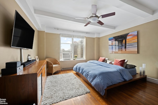 bedroom featuring a ceiling fan, wood finished floors, and beamed ceiling