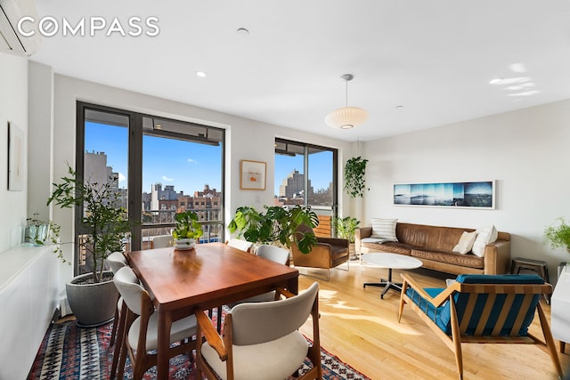 dining room with light wood-type flooring, a view of skyline, and recessed lighting