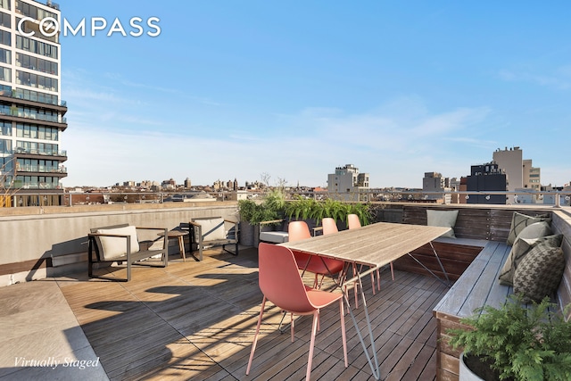 wooden terrace featuring a view of city and outdoor dining area