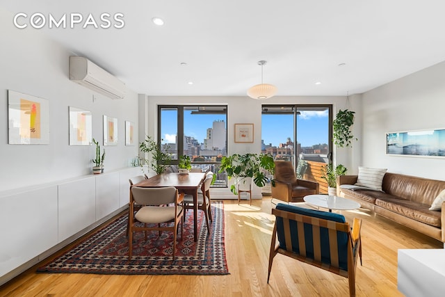living room featuring a wall unit AC, wood finished floors, recessed lighting, and a skyline view