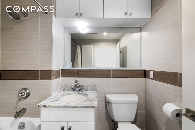 bathroom with tile walls, toilet, shower / tub combo with curtain, and vanity
