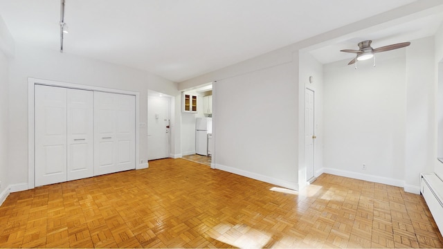 2 Tudor City Pl Unit Gns, New York City, NY 10017 - unfurnished bedroom featuring freestanding refrigerator, baseboards, a baseboard radiator, and ceiling fan