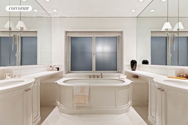 40 E 72nd St Unit 5, New York City, NY 10021 - bathroom featuring tile patterned floors, two vanities, and a garden tub