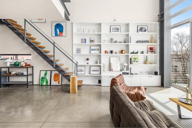 living room with stairs and finished concrete flooring