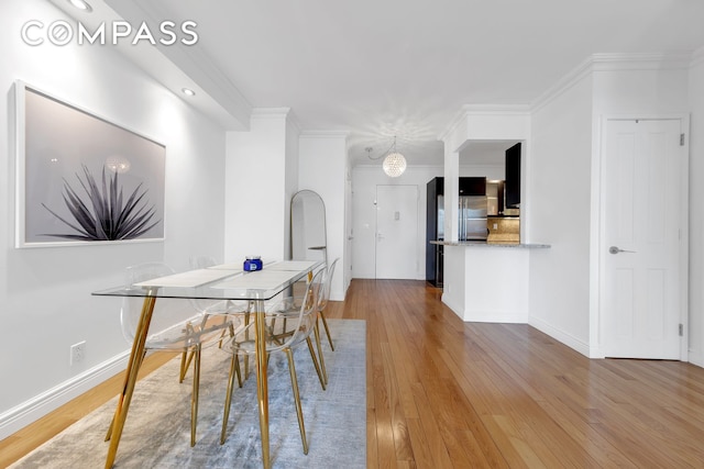 unfurnished dining area featuring crown molding, baseboards, an inviting chandelier, recessed lighting, and hardwood / wood-style floors