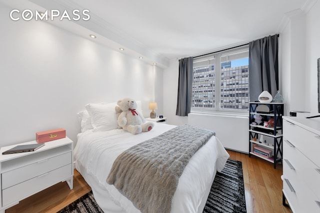bedroom featuring crown molding, recessed lighting, and wood finished floors