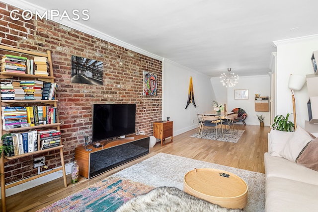living area featuring ornamental molding, a chandelier, wood finished floors, and baseboards