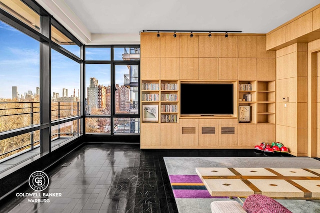 170 E End Ave Unit 8/9E, New York City, NY 10128 - living area with track lighting, a view of skyline, built in features, and a wall of windows