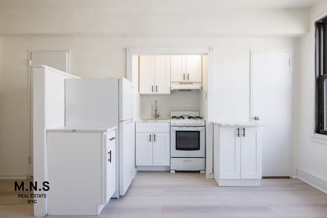 98-19 64th Ave Unit 6-Gg, New York City, NY 11374 - kitchen featuring white appliances, under cabinet range hood, backsplash, light wood-style flooring, and light countertops