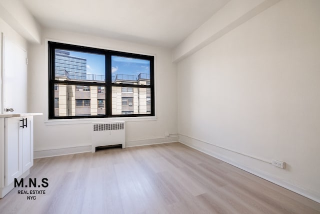 98-19 64th Ave Unit 6-Gg, New York City, NY 11374 - empty room featuring radiator, light wood-type flooring, and baseboards