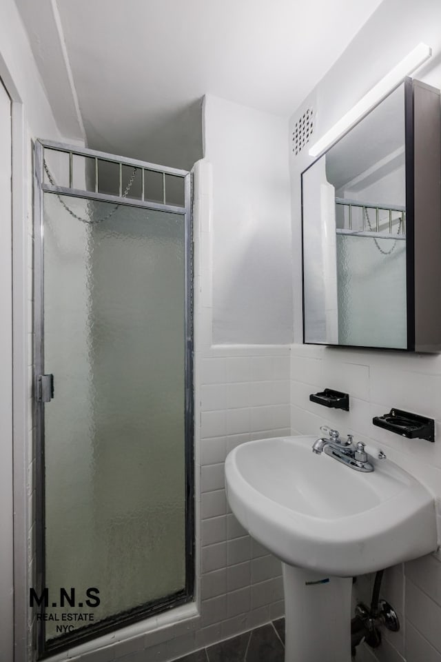 98-19 64th Ave Unit 6-Gg, New York City, NY 11374 - full bath with a stall shower, tile walls, and tile patterned floors