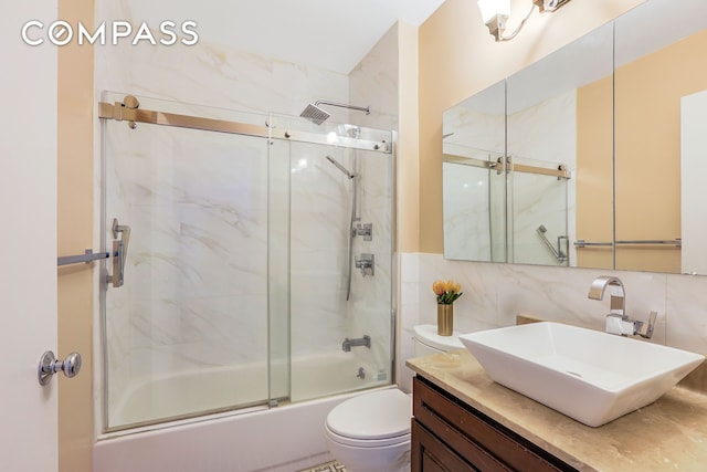 bathroom featuring toilet, enclosed tub / shower combo, vanity, tasteful backsplash, and tile walls