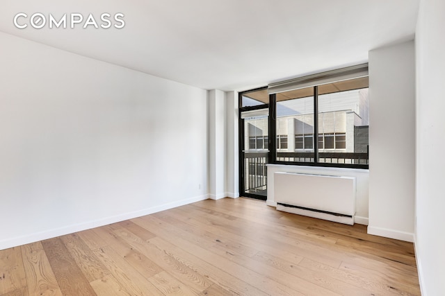 spare room with hardwood / wood-style floors and baseboards