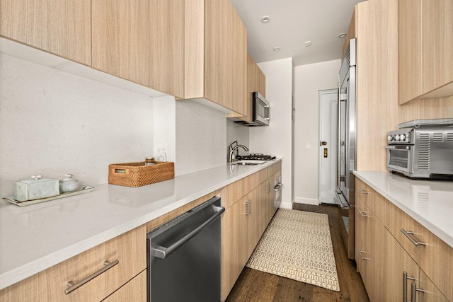 55 Park Ave Unit 7-W, New York City, NY 10016 - kitchen featuring modern cabinets, stainless steel appliances, dark wood-style flooring, and light countertops