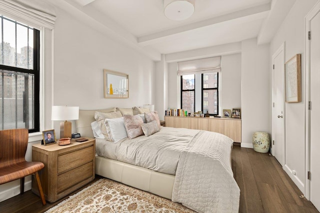 bedroom featuring multiple windows, dark wood finished floors, and beamed ceiling