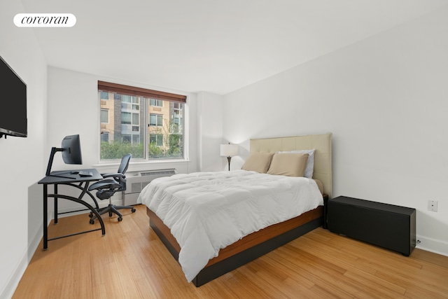 bedroom featuring light wood finished floors and baseboards