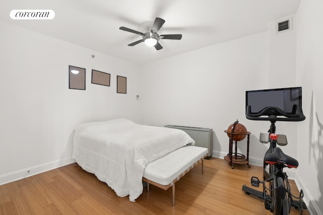 bedroom featuring light wood-type flooring, baseboards, and ceiling fan