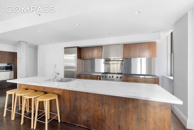 150 Nassau St Unit 18Ab, New York City, NY 10038 - kitchen featuring a large island, a breakfast bar area, high quality appliances, a sink, and dark wood finished floors