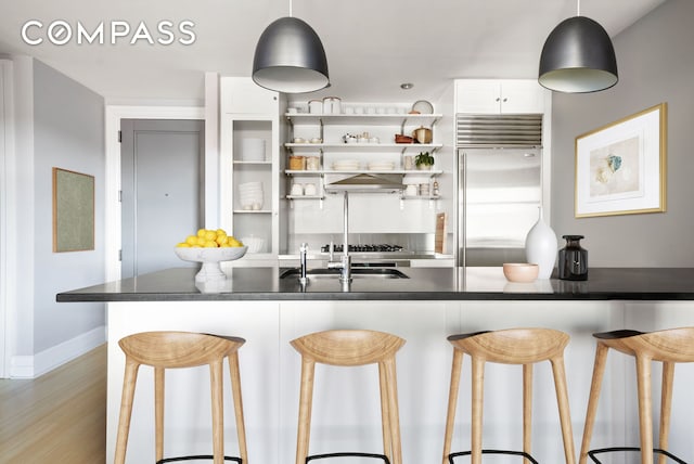 110 Livingston St Unit 7P, New York City, NY 11201 - kitchen featuring stainless steel built in fridge, a breakfast bar area, baseboards, light wood finished floors, and a sink