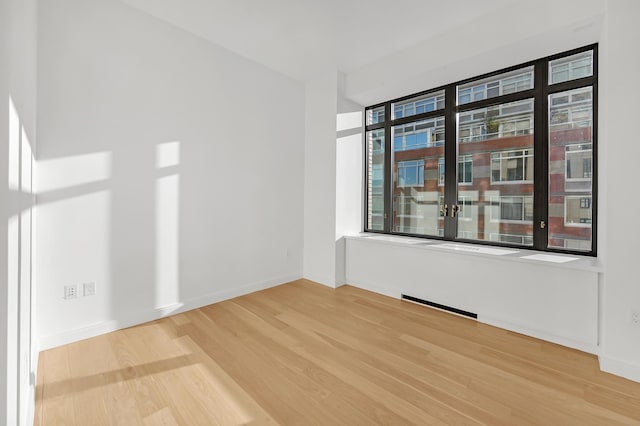 empty room with baseboards and wood finished floors