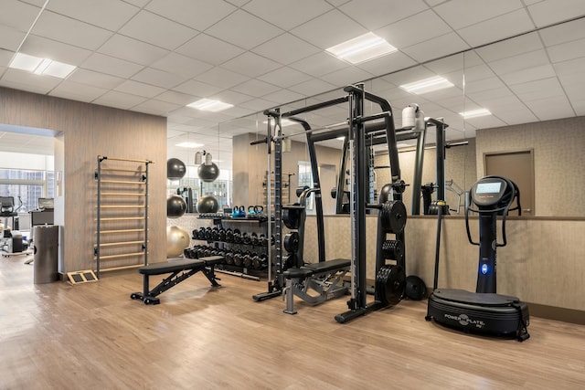 gym with wood finished floors and wallpapered walls