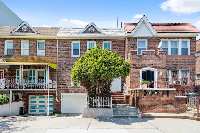 309 Covert St, New York City, NY 11237 - view of property featuring an attached garage, brick siding, cooling unit, and driveway